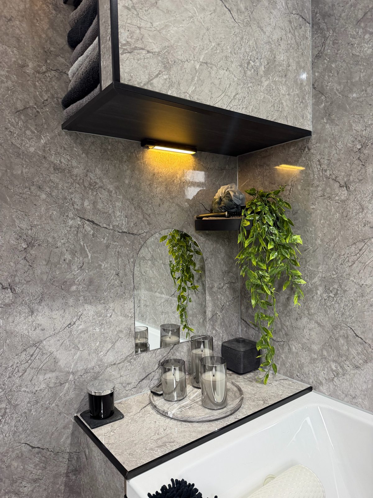 Marble bathroom arched mirror with candles and hanging plant