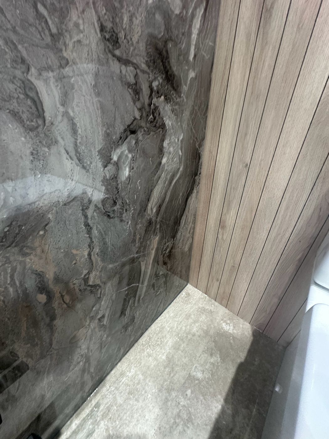 Bathroom corner with marble-effect tiles and oak joinery