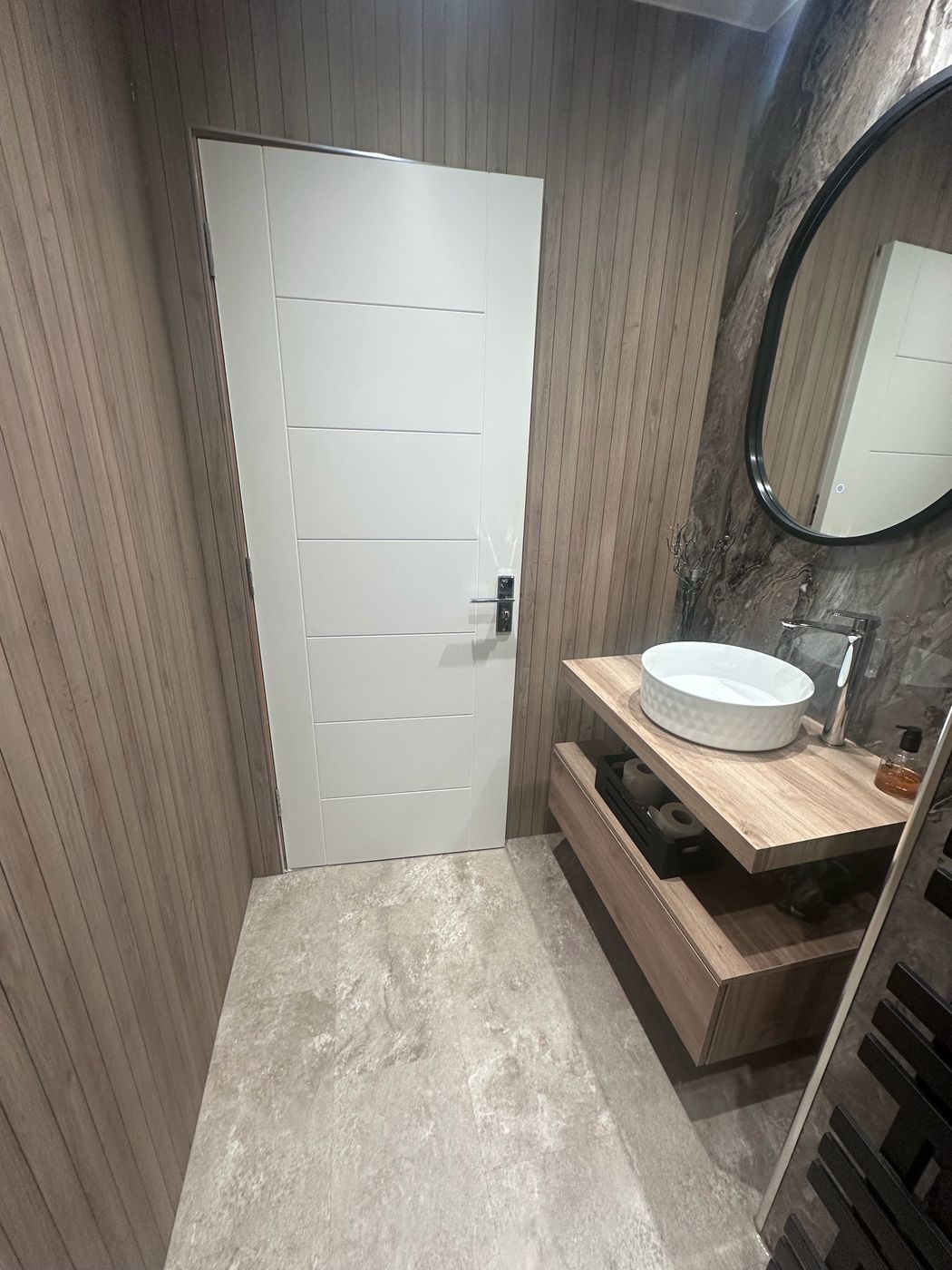 Bathroom with vertical oak slat wall paneling around toilet area