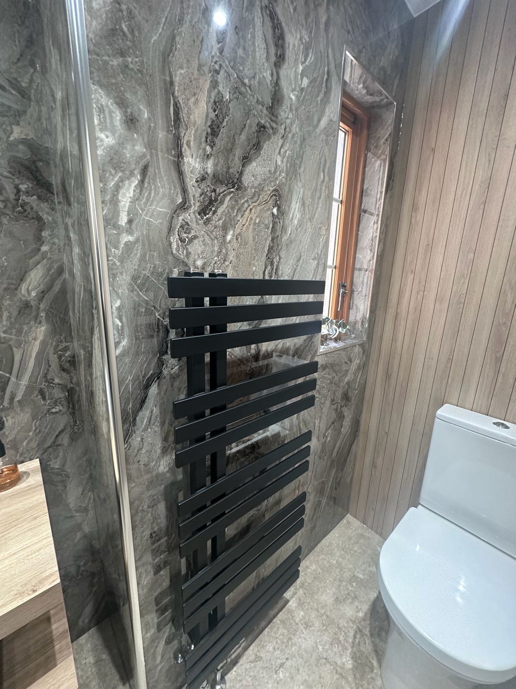 Floating oak vanity with vessel sink, marble-effect tiles and vertical oak slat wall — bathroom by EscapeHaus Joinery