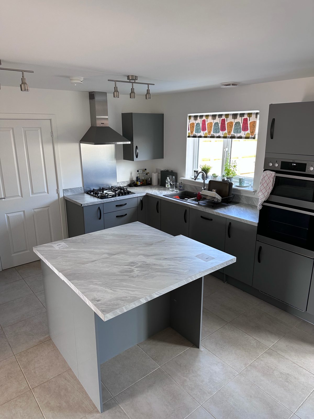 Modern matte grey handleless kitchen with marble-effect island