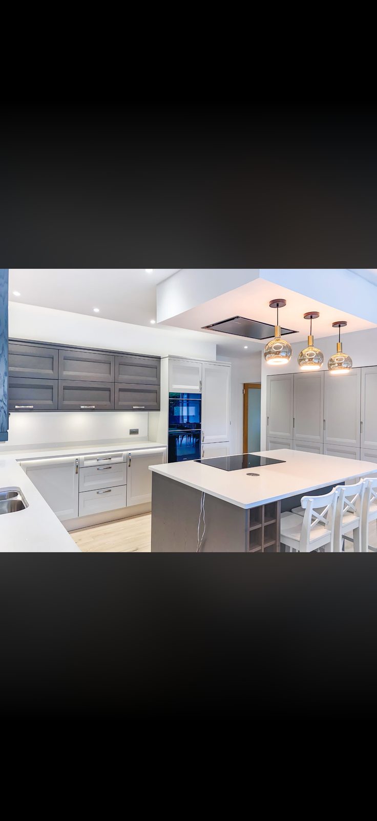 Modern kitchen island with wine rack, pendant lights and charcoal units