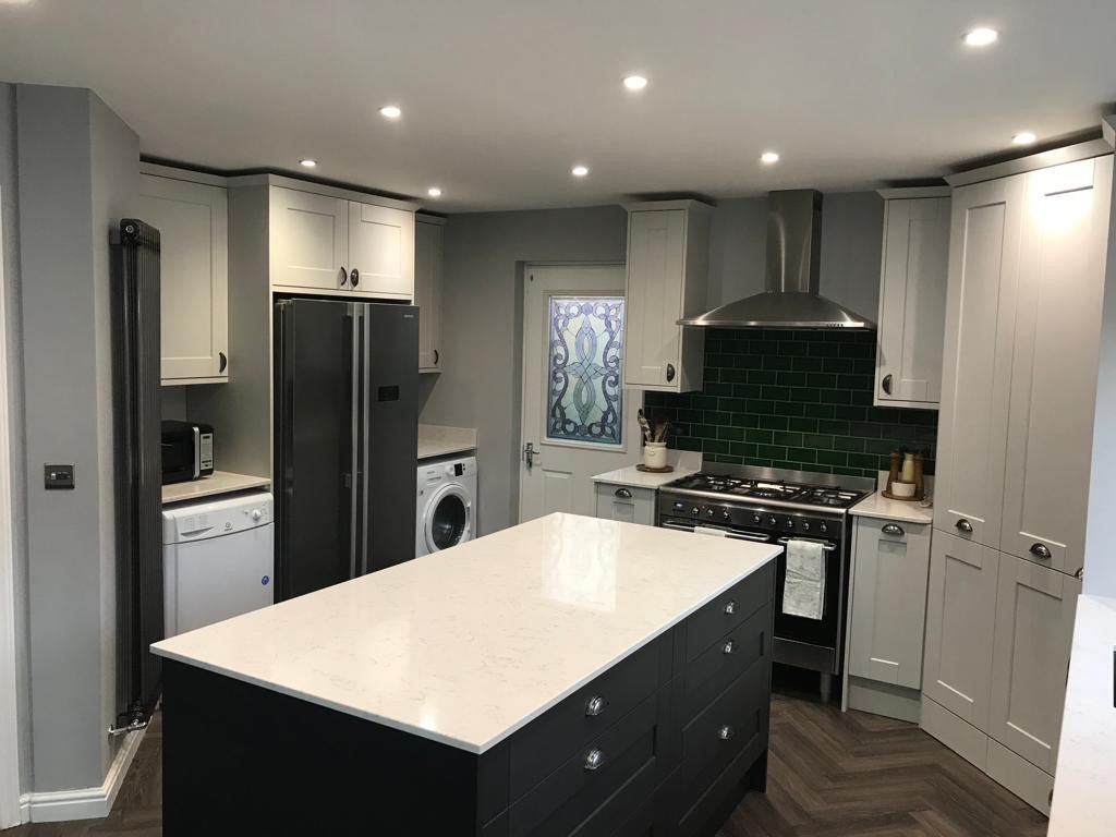 Light grey Shaker kitchen with charcoal island, green metro tiles and herringbone floor