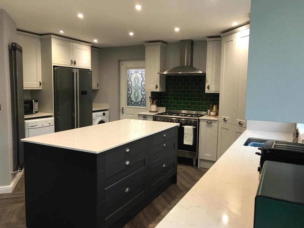 Light grey Shaker kitchen with dark island, green metro splashback and herringbone flooring — fitted by EscapeHaus Joinery